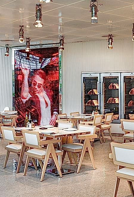 Open and airy dining area at Nusr-Et İstinye, located within İstinye Park shopping mall, with minimalist white chairs and tables, offering a relaxed and luxurious dining experience.