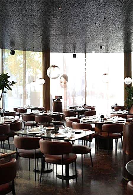 Elegant dining area at Nusr-Et London with floor-to-ceiling windows, modern decor, and comfortable seating for a premium steakhouse experience.