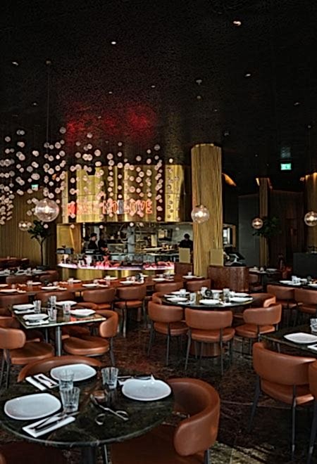 Sophisticated interior of Nusr-Et London featuring a stylish open kitchen, sleek lighting, and a vibrant ambiance for fine dining.