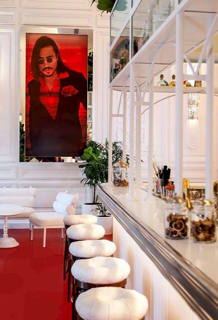 Chic bar area at Nusr-Et Maçka Palas, featuring a stylish portrait of Nusret Gökçe and sophisticated white decor for an upscale dining experience.