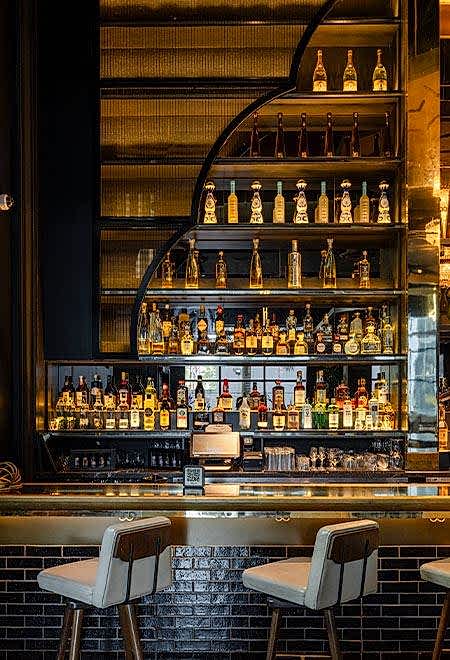 Stylish bar at Nusr-Et Miami featuring a wide selection of premium spirits, creating a luxurious atmosphere for cocktails and fine dining.
